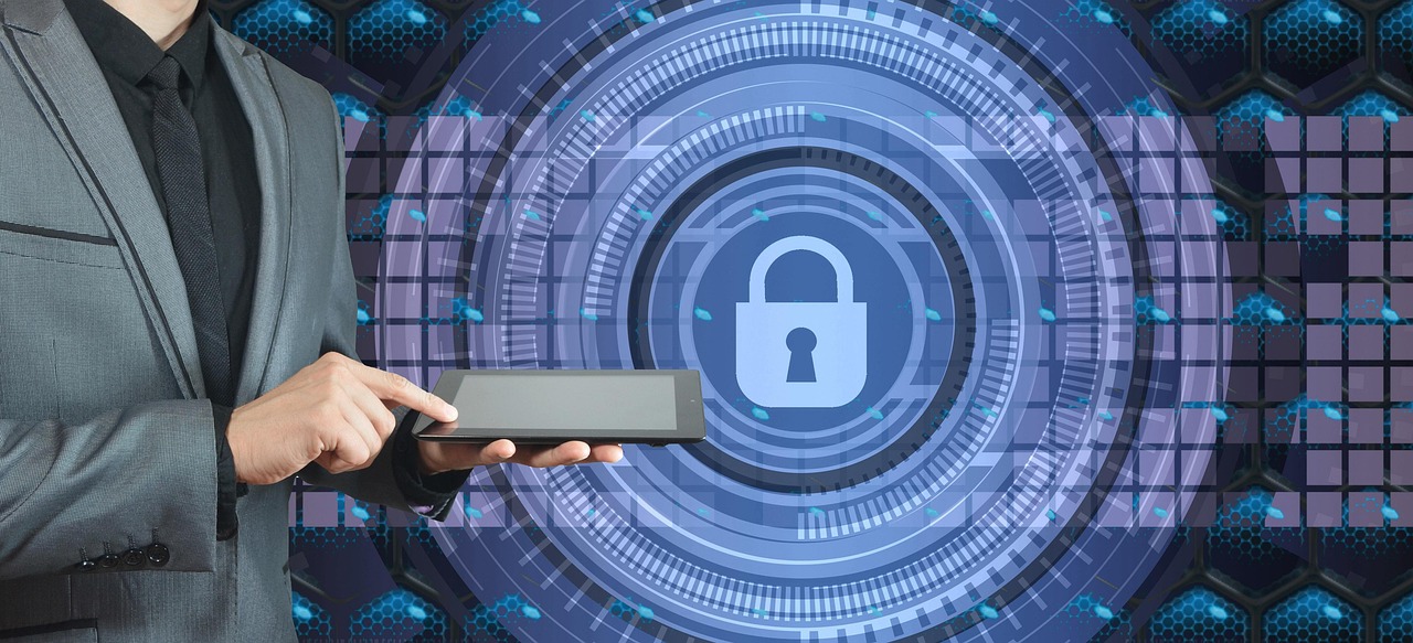 テクノロジー風のロック鍵のイメージを背景に、タブレットを操作する、グレージャケットに黒シャツの男